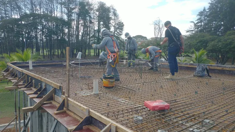 Equipe executando armação de aço para laje de concreto