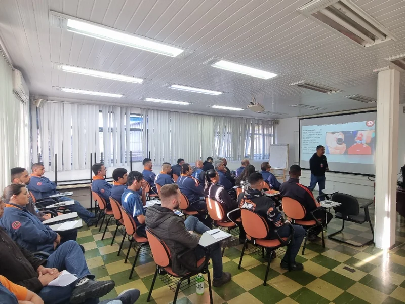 Treinamento de primeiros socorros em sala com trabalhadores usando equipamentos de proteção